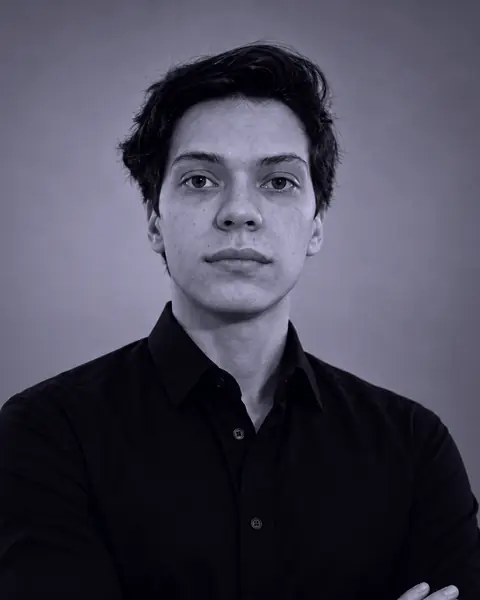 Portrait of Andrés Gil: facing the camera, in a dark shirt, against a plain background.